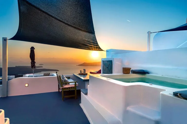 a rooftop with a hot tub and a sun set