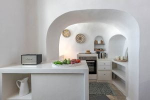 a white kitchen with a white countertop and a white oven
